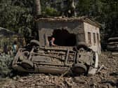A local resident stands next to destroyed cars after an overnight Russian attack on Kyiv, Ukraine