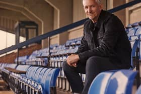 Gary Lineker sat in the stands at a sports ground