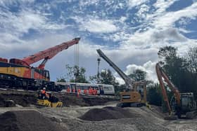 A train carriage which derailed on the approach to Lewes station in East Sussex being lifted as part of the recovery operation