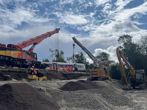 A train carriage which derailed on the approach to Lewes station in East Sussex being lifted as part of the recovery operation