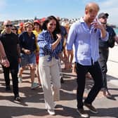 Duke and Duchess of Sussex walking along a beach