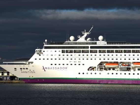 The cruise ship Ambition docked, under grey skies
