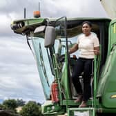 Kemi Badenoch exiting a large green farm vehicle
