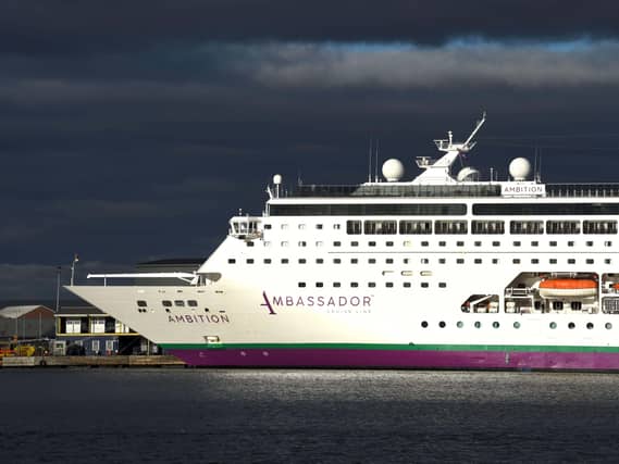 The cruise ship Ambition docked, under grey skies