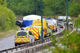 Police officers at the scene of the fatal crash involving a police car and a Volkswagen Passat on the A66