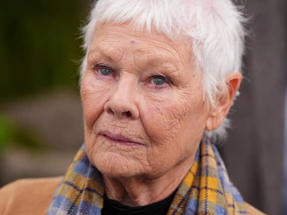 Dame Judi Dench in a brown coat and printed scarf at the Chelsea Flower Show 2026