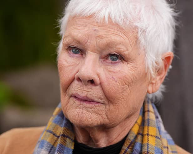 Dame Judi Dench in a brown coat and printed scarf at the Chelsea Flower Show 2026