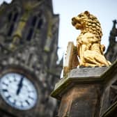 A view of a golden statue and clock tower