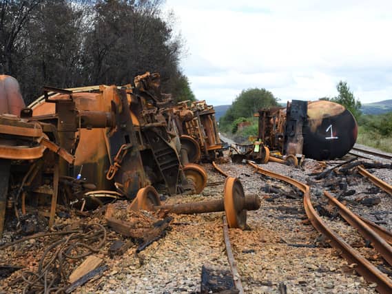 Burned out fuel wagons on a damaged railway line