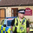 A police officer stands guard at Johnsons of Old Hurst