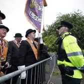 A police officer speaks to members of the Orange Order