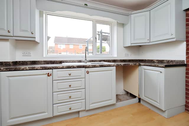 The fitted kitchen features base and wall units, generous worktop space and access to the utility area
