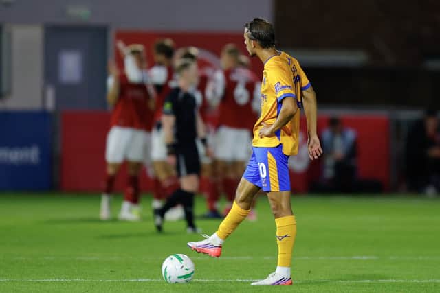 Tom Sang on the halfway line as Fleetwood Town celebrate a fourth goal against Shrewsbury Town in the distance 