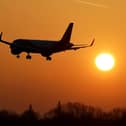 A flight takes off in the hazy morning sunshine