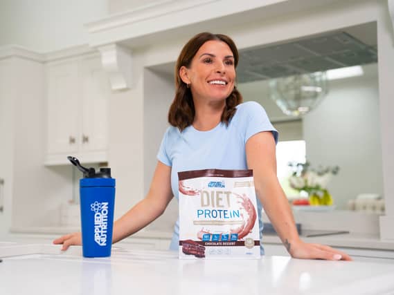 Coleen Rooney with a packet of Applied Nutrition Diet Protein and branded water bottle
