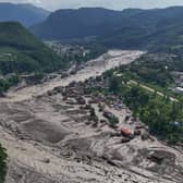 Damaged houses stand near the swollen, debris-choked banks of the Trishuli River after flash floods in Nepal’s Nuwakot district