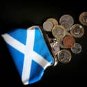 Coins on a table next to a Saltire purse