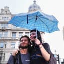 People shelter from the rain under an umbrella, in Westminster, central London.