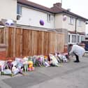 A woman laying flowers near houses in Middlesbrough