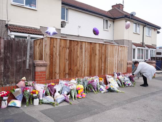 A woman laying flowers near houses in Middlesbrough