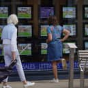 People looking at advertisements in an estate agents window