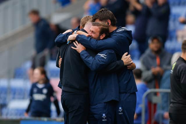 Get in! Gavin Cowan and his Shrewsbury Town management team celebrated the win with a group hug