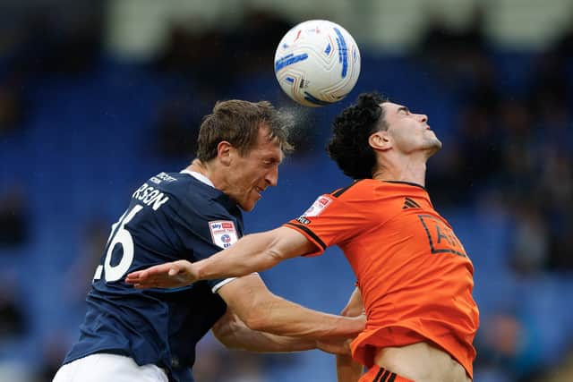 Tom Anderson heads clear for Shrewsbury Town against Salford City