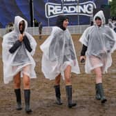 Festivalgoers cover up with plastic ponchos for the heavy rainfall at the Reading Festival at Little John’s Farm, Reading, Berkshire.