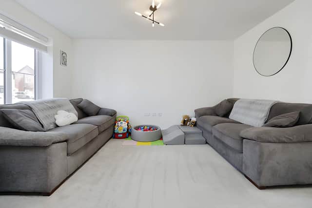 The generous living room provides a dedicated reception space within the home's modern and flexible ground-floor layout