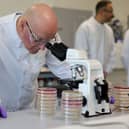 John Swinney peers into a microscope