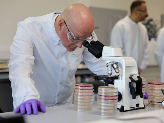 John Swinney peers into a microscope