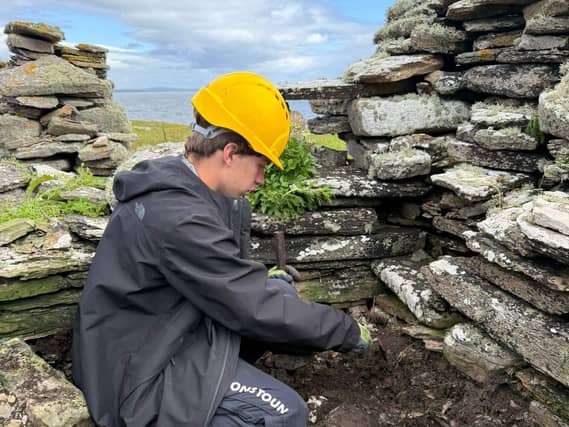 A person in a hard hat working within a ruin