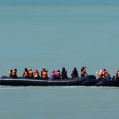 Two small boats hug the coastline near Ault in France in June, as people thought to be migrants are collected along the coastline before an attempt to cross the Channel