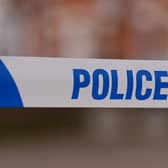Police tape stretched over a road