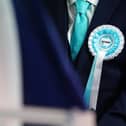 Close-up of a person wearing a Reform UK rosette