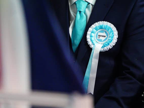 Close-up of a person wearing a Reform UK rosette