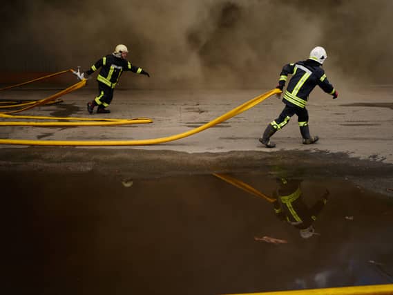 Firefighters try to extinguish a fire at a destroyed warehouse after Russian drone attacks on the outskirts of Kyiv