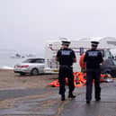 Police officers walk past a pile of discarded life jackets at Eastney Point, near Eastney Beach, Portsmouth