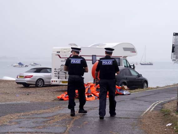 Police officers walk past a pile of discarded life jackets at Eastney Point, near Eastney Beach, Portsmouth