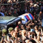 Coffin draped in Serbian flag makes its way through crowd