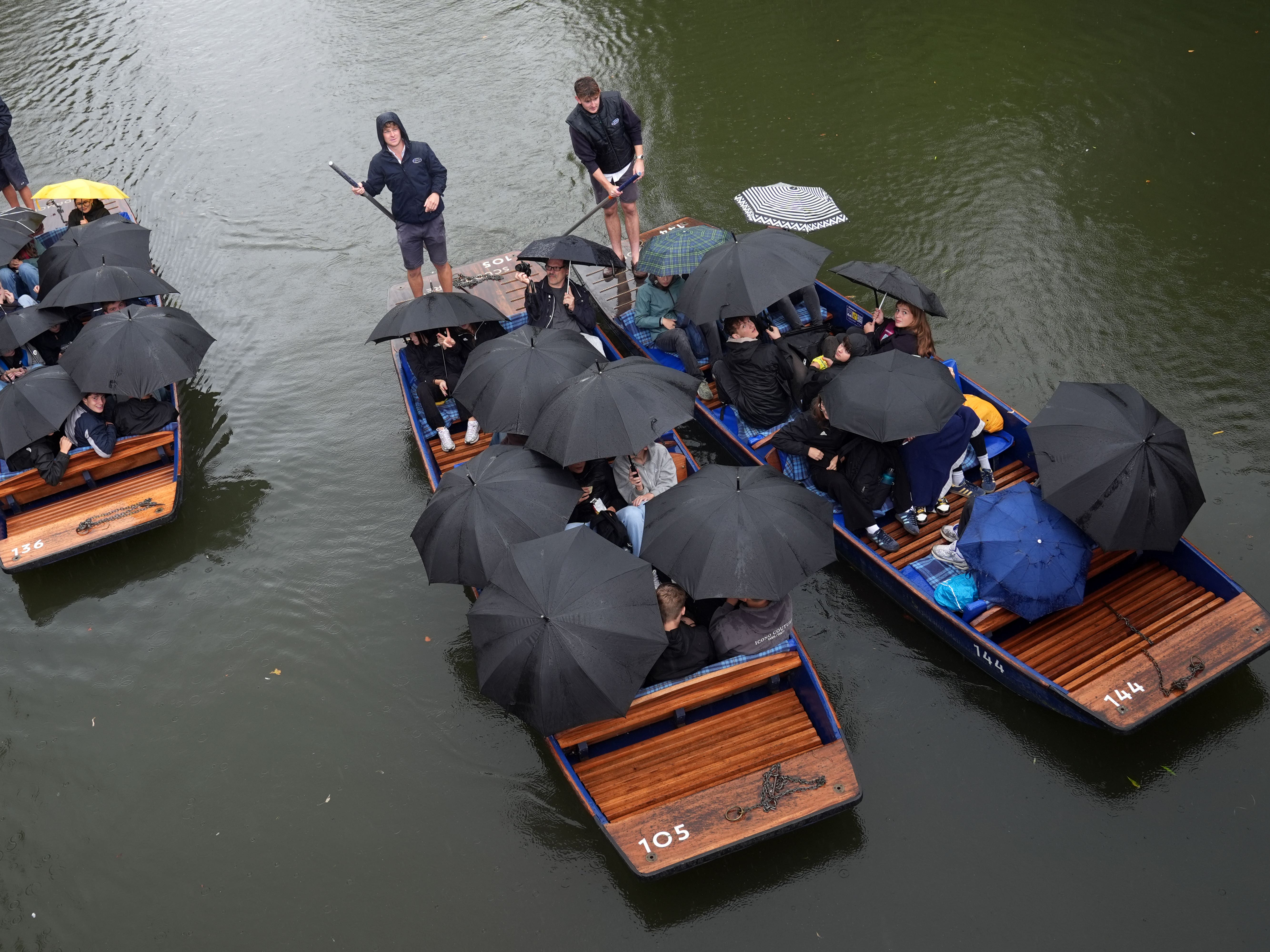 People use umbrellas to shelter from the rain while on boats