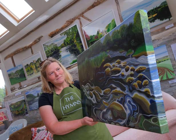 Artist Lucy Burden at The Hymns with one of her River Wye paintings