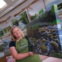 Artist Lucy Burden at The Hymns with one of her River Wye paintings