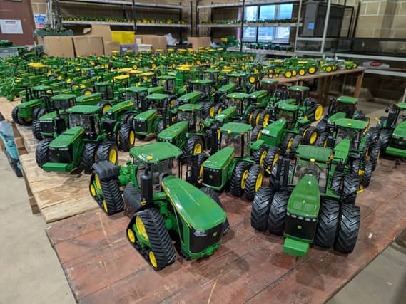 A view of dozens of green and yellow John Deere tractor toys