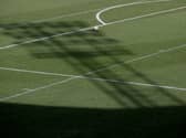 The shadow of a floodlight on the pitch