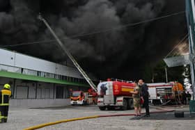 Firefighters tackle a blaze, with a huge cloud of black smoke overhead