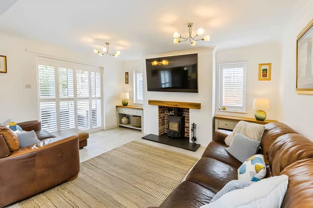A log burner provides a striking focal point in the open-plan living space