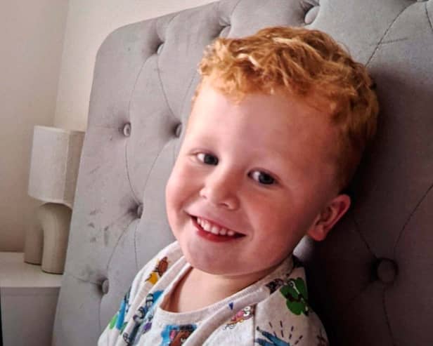 Handout photo of Noah Woods smiling, while sitting on a bed