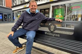 Councillor Paul Davis in Wellington Town Centre sitting on one of the new benches.