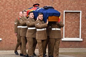 The bearer party carries the coffin into the funeral of Norman Irwin